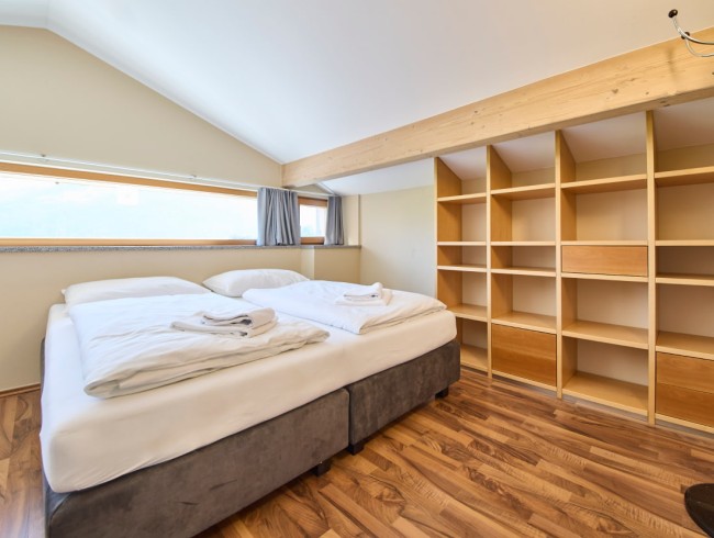 Gem&uuml;tliches Doppelbett mit viel Stauraum im hellen Schlafzimmer