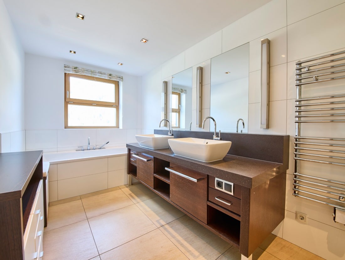 Modernes Badezimmer mit Badewanne, Doppelwaschbecken und Handtuchheizk&ouml;rper